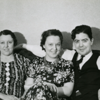 Un homme et deux femmes assis sur un divan.