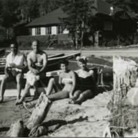 Deux hommes et deux femmes assis dans le sable