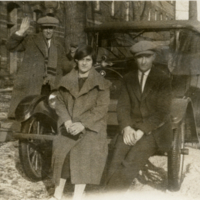 Deux hommes et une femme devant une voiture