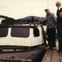 Un homme et une femme à côté d'un bateau sur un quai